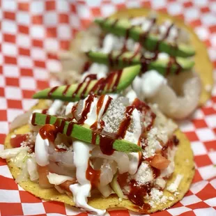 two nachos with sauce and avocado