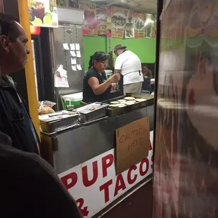 La señora muy amable asiendo popusa