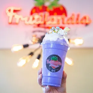 a hand holding a purple drink