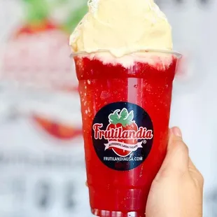 a hand holding a cup of ice cream