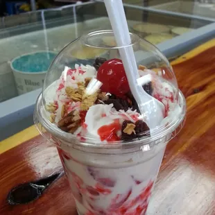 Fresas con crema. Sweet strawberries with cream; topped with coconut flakes and a cherry.