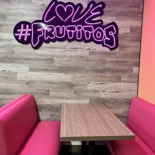 a pink booth with a wooden table