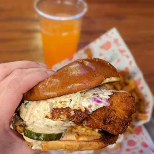 a hand holding a chicken sandwich