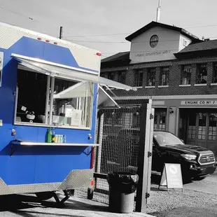 a blue food truck parked on the side of the road