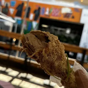 a hand holding a fried chicken sandwich