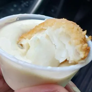 a hand holding a cup of food