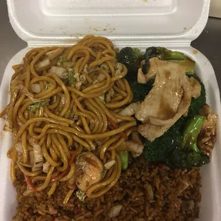 a take out container with noodles, broccoli, and chicken