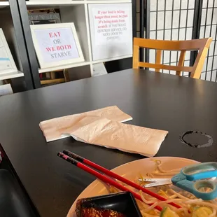 a plate of noodles and chopsticks on a table