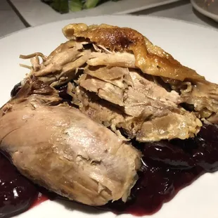 Dried old tasting duck on top of cherry sauce