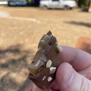 a hand holding a piece of candy