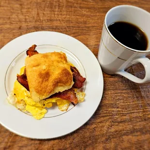 Bacon, egg and cheese biscuit breakfast sandwich with coffee