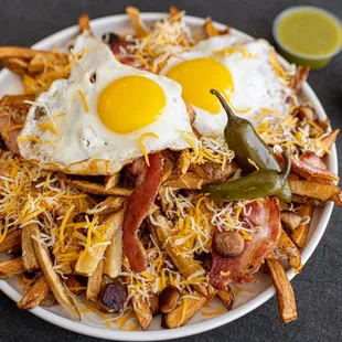 a plate of fries with fried eggs