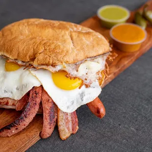 a bacon and egg sandwich on a wooden cutting board