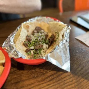 Barbacoa taco! It comes undressed; my husband added onions and cilantro from the salsa bar.