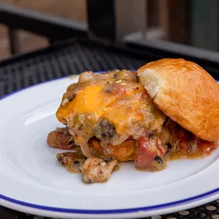 Slopper Sliders: Two open-faced Burgers with American Cheese, Smothered in Pueblo Green Chile, topped with Diced Onions.