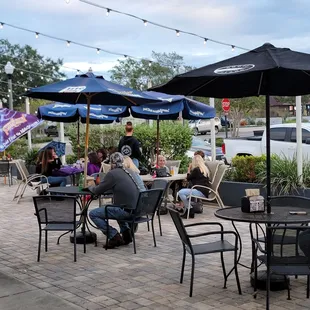 people sitting at tables with umbrellas