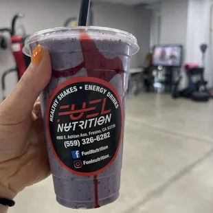 a hand holding a cup of juice