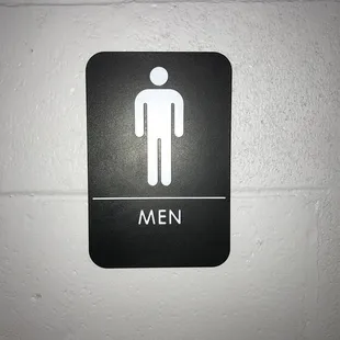 a men's restroom sign on a wall