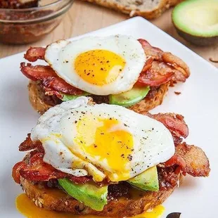 a plate of food with bacon, eggs, and avocado