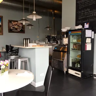 a kitchen with a refrigerator, table, and chairs