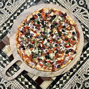 Supreme pizza with pepperoni, Italian sausage, mushrooms, black olives, red peppers, artichokes, onions and topped with fresh parsley.