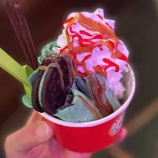 a hand holding a cup of ice cream