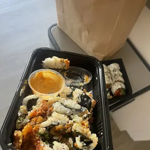 a person holding a tray of sushi