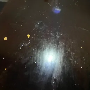 a black counter top with yellow chips on it