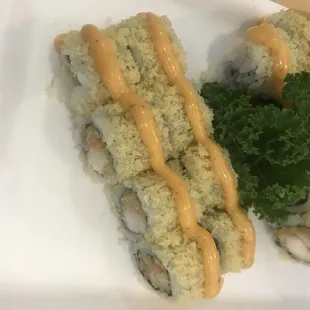 a plate of sushi with sauce and lettuce
