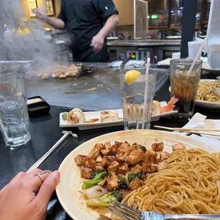 a plate of noodles with shrimp and broccoli