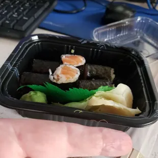 a hand holding a container of food