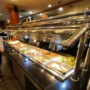 a woman standing in front of a buffet full of food