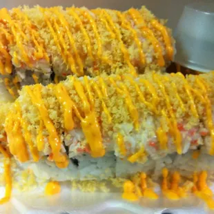two pieces of sushi covered in cheese