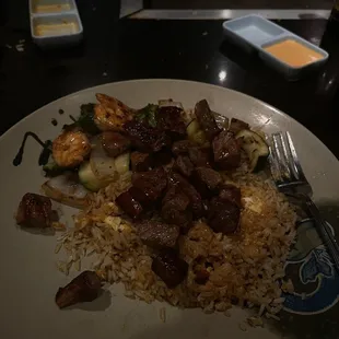 a plate of rice with meat and vegetables