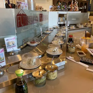 At the bar next to the conveyor belt.