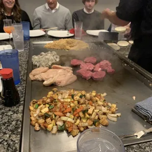 a group of people sitting around a grill