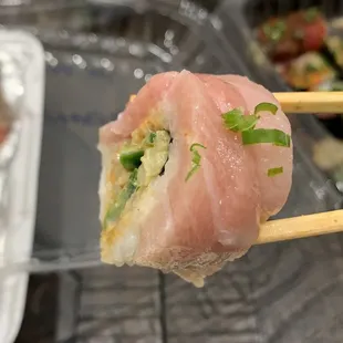 a plate of sushi with chopsticks