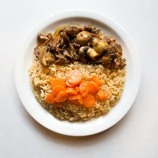 a plate of food with rice, carrots and mushrooms
