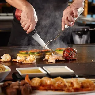 a chef preparing food on a grill