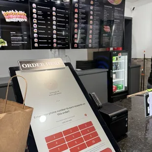 The ordering kiosk and the menu in the background.