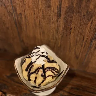 a bowl of ice cream with chocolate drizzle