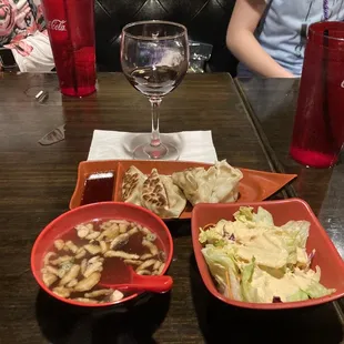 three bowls of food and a glass of wine