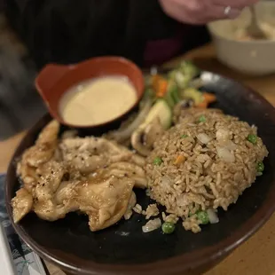 a plate of rice, chicken and vegetables
