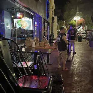 a man walking down a sidewalk at night