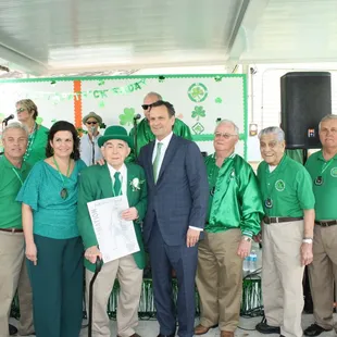 a group of men and women in green shirts