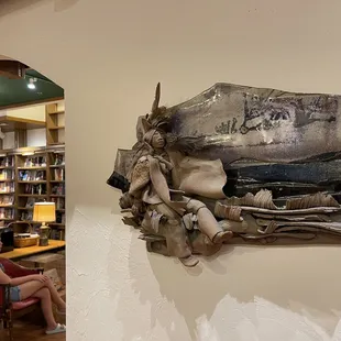 Nice artwork  on the wall with a peek into the next room.