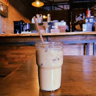 a glass of iced coffee on a wooden table