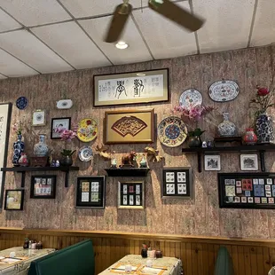 a dining room with a variety of asian plates on the wall