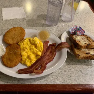 German breakfast. Already buttered raisin toast, prefabed potato pancakes with crisp bacon and scrambled eggs.