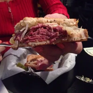 a person holding a half eaten sandwich